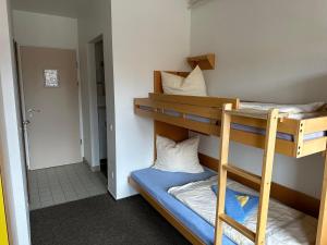 a room with two bunk beds and a hallway at Jugendherberge Tönning in Tönning