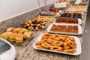 a buffet of different types of food on a counter at Hotel Caiuá in Umuarama
