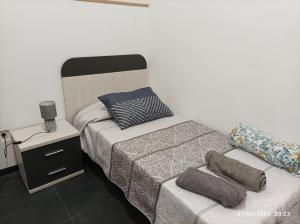 Habitación pequeña con cama y mesita de noche en Casa La Isleta, playa Las Canteras, puerto y tranquilidad, en Las Palmas de Gran Canaria