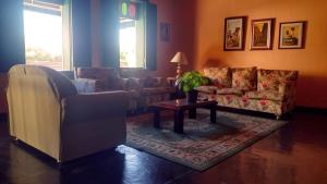 a living room with two couches and a coffee table at Pousada Vale das Palmeiras in Vassouras