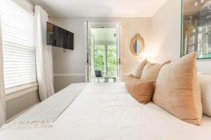 een slaapkamer met een groot wit bed met kussens bij Kersey Coates at Southmoreland on the Plaza in Kansas City
