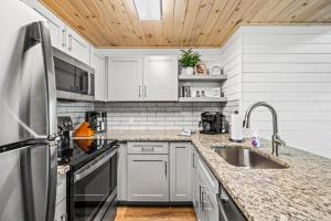 a kitchen with white cabinets and a sink at Smoke of the Mountains in Gatlinburg