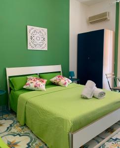 a green bedroom with a bed with two pillows at Mille tramonti Agropoli sunset suite in Agropoli +45 photos