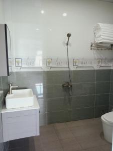 uma casa de banho com um chuveiro, um lavatório e um WC. em Hoàng Anh Côn Đảo Hotel em Con Dao
