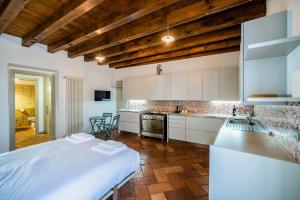 a kitchen with white cabinets and a large white bed at Casa Viola in Bergamo