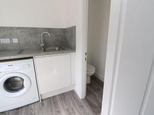 a laundry room with a sink and a washing machine at Borve House, Kilchoan in Kilchoan
