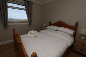 a bedroom with a large bed with towels on it at Borve House, Kilchoan in Kilchoan
