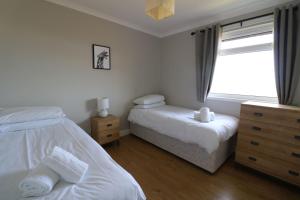 a bedroom with two beds and a window at Borve House, Kilchoan in Kilchoan