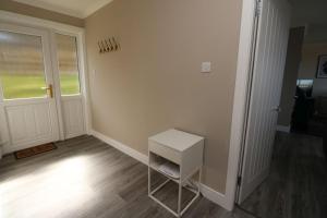 a small white stool in a room with a door at Borve House, Kilchoan in Kilchoan