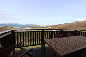 a table and chairs on a balcony with a view of the ocean at Borve House, Kilchoan in Kilchoan