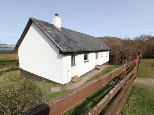 a white house on the side of a fence at Borve House, Kilchoan in Kilchoan