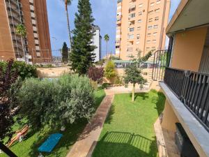 a small backyard with grass and trees and buildings at Apartamento Acacias IV -5 in Benidorm