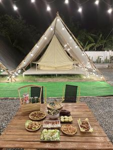 een picknicktafel met eten en een tent bij SAY Camp Forest in Can Gio