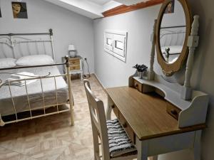 una camera da letto con scrivania, letto e specchio di Villa Maxim in Corfu Town a Anemómylos