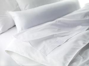1 cama no hecha con sábanas y almohadas blancas en The Westin Savannah Harbor Golf Resort & Spa, en Savannah
