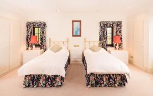 a bedroom with two beds and two mirrors at Tigh Chailein in Tarbert