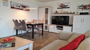sala de estar con mesa y TV en Bonna's Ostsee Oase - Haus Baltic - Whg 180 - Inkl gratis WLAN und Saisonstrandkorb, en Grömitz