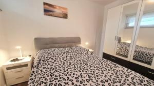 Un dormitorio con una cama en blanco y negro y un espejo en Bonna's Ostsee Oase - Haus Baltic - Whg 180 - Inkl gratis WLAN und Saisonstrandkorb, en Grömitz