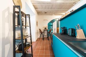 a kitchen with a blue wall and a counter at Goldliebe in Konstanz