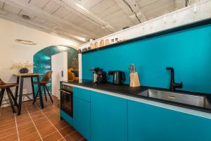 a kitchen with blue cabinets and a sink and a table at Goldliebe in Konstanz