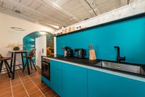 eine Küche mit blauen Schränken, einem Waschbecken und einem Tisch in der Unterkunft Goldliebe in Konstanz