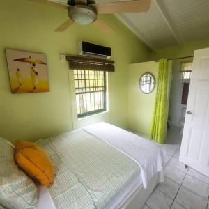 een slaapkamer met een bed en een plafondventilator bij Petti Rosa Villa in Gros Islet