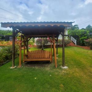 een bank onder een tuinhuisje in een tuin bij Petti Rosa Villa in Gros Islet