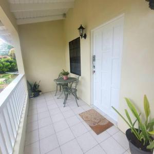 een veranda met een tafel en een witte deur bij Petti Rosa Villa in Gros Islet
