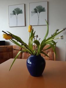 a blue vase with a yellow flower on a table at Ferienzentrum Bodensee in Oberteuringen