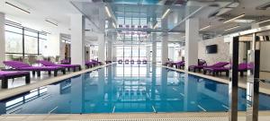 a swimming pool with purple chairs in a building at Kasimir Resort Hotel & SPA in Bukovel