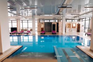 una grande piscina con sedie viola in un edificio di Kasimir Resort Hotel & SPA a Bukovel