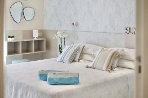 a white bed with two towels on top of it at Hotel Flora in Cattolica