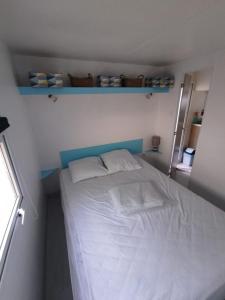 米米藏的住宿－Mobil home 4 couchages，小卧室配有带白色床单和枕头的床