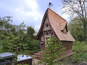 a small wooden church with a cross on the roof at La cabane de Merlin in Les Molières