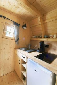 - une cuisine avec évier et cuisinière dans une cabine dans l'établissement La cabane de Merlin, à Les Molières