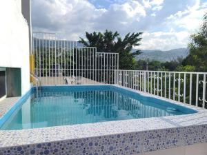 a blue swimming pool with a white fence at 2 bedroom suite Peguyille 