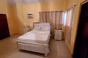a bedroom with a white bed and two night stands at 2 bedroom suite Peguyille 