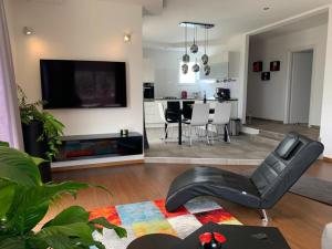 een woonkamer met een zwarte leren stoel en een televisie bij Apartment Dora in Makarska