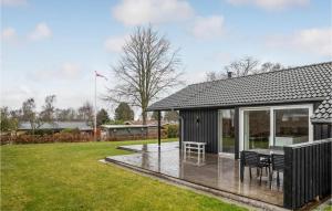 una casa negra con terraza y mesa en Amazing Home In Stubbekbing With Wifi, en Stubbekøbing