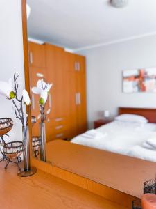 a bedroom with a bed and a wooden table with vases at Broj jedan Delux in Soko Banja +33 photos