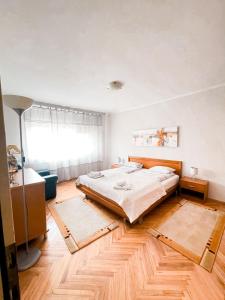 a bedroom with a large bed and wooden floors at Broj jedan Delux in Soko Banja