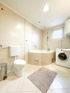 a bathroom with a toilet and a tub and a washing machine at Broj jedan Delux in Soko Banja