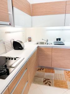 a kitchen with white counters and wooden cabinets at Broj jedan Delux in Soko Banja