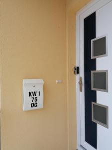 een deur met een bord waarop staat kiwi uit bij Ostseetraum Igelring in Gelbensande