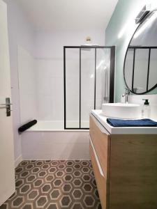 łazienka z wanną, umywalką i lustrem w obiekcie Cosy 30m in the heart of Villeurbanne w mieście Villeurbanne