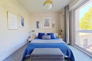 ein Schlafzimmer mit einem blauen Bett und einem großen Fenster in der Unterkunft Les Jardins de la Muse, piscine couverte, spa et fitness in Basse-Goulaine + 36 Fotos