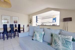 een woonkamer met een blauwe bank en een tafel bij Les Jardins de la Muse, piscine couverte, spa et fitness in Basse-Goulaine