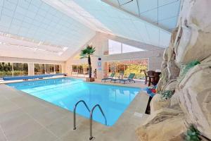 ein großes Schwimmbad in einem großen Gebäude in der Unterkunft Les Jardins de la Muse, piscine couverte, spa et fitness in Basse-Goulaine