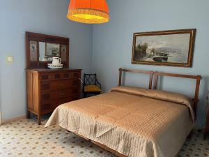 um quarto com uma cama, uma cómoda e um espelho em Il tesoro di Fea em Giardini Naxos