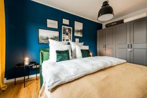 1 dormitorio con paredes azules y 1 cama grande en Klassen Stay - Exklusives Apartment - Zentral und 4km zur Messe -Kingsizebett en Essen